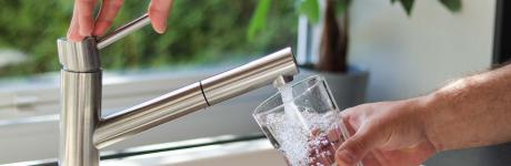 Drinking water faucet filling up a glass
