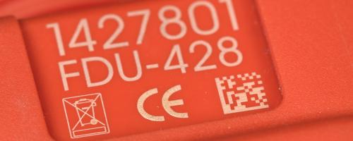 Datamatrix marking on a red plastic part with engraved reference and CE symbols